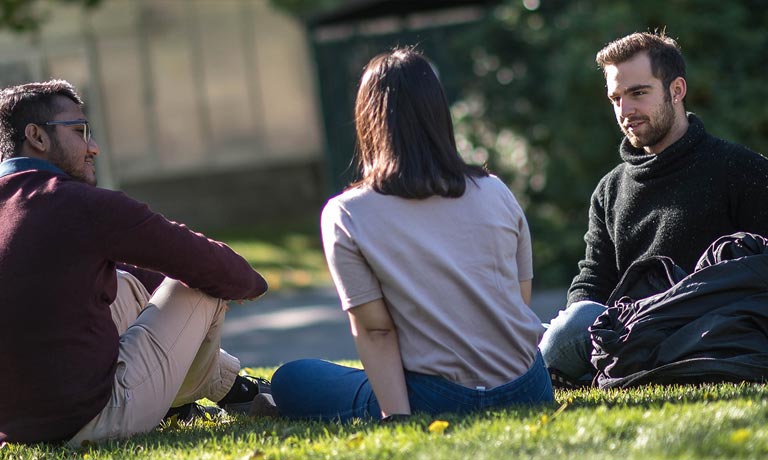 Students sitting on the grass at UBCO campus